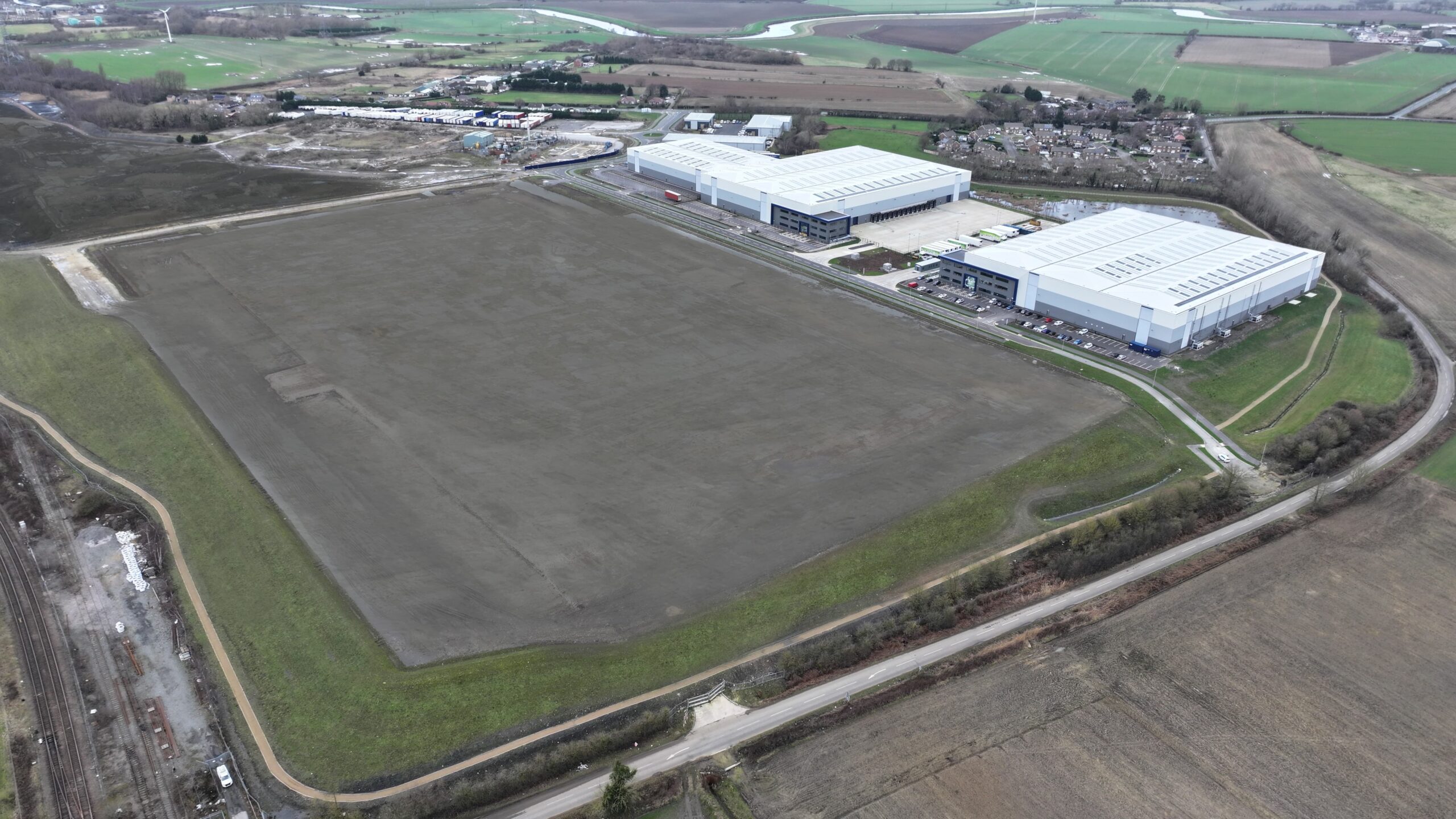 invest-strategic-Konect_62 Aerial photograph showing large brownfield space with industrial units located in the distance.