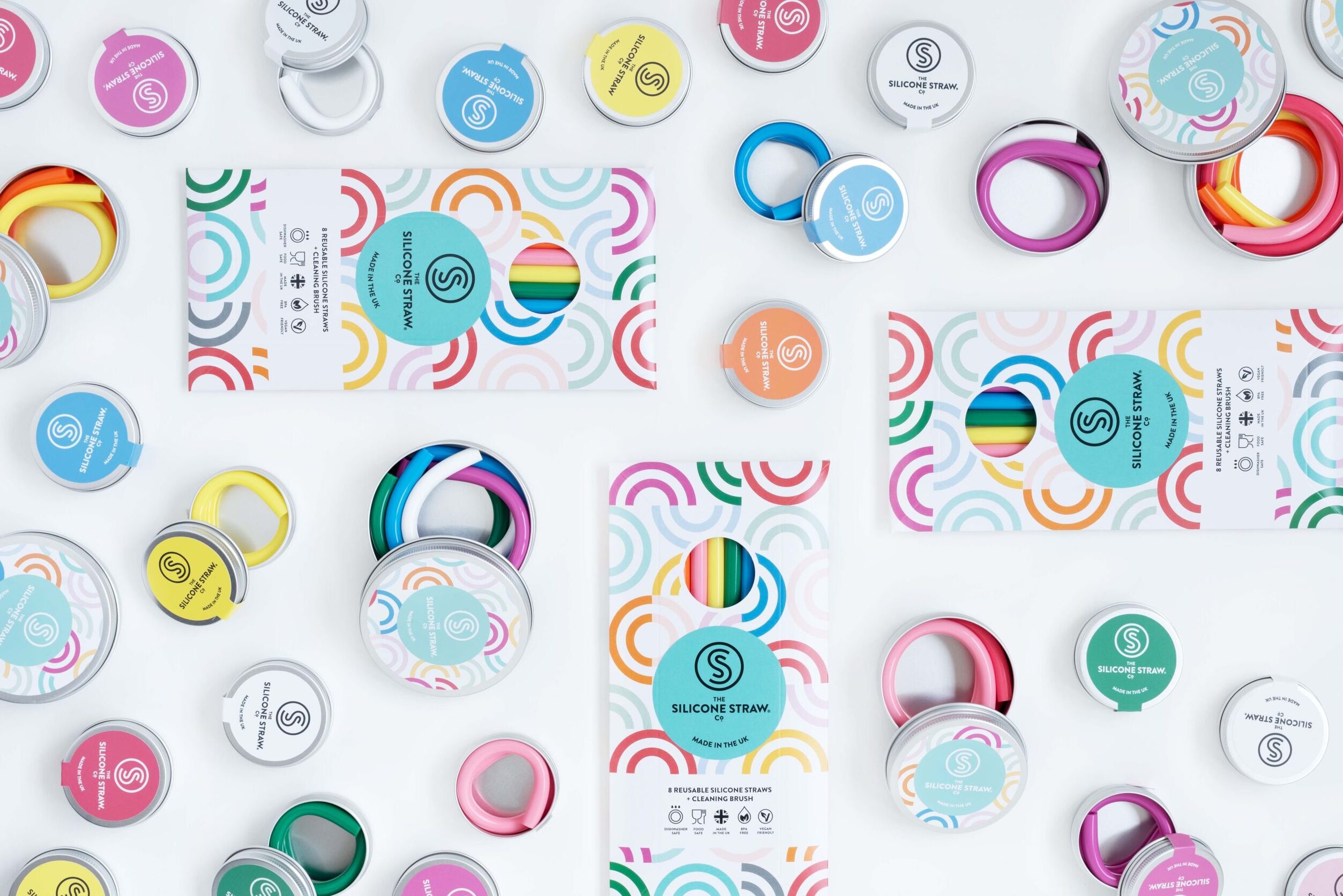 Reusable silicone straws in colourful circular packaging on a white background